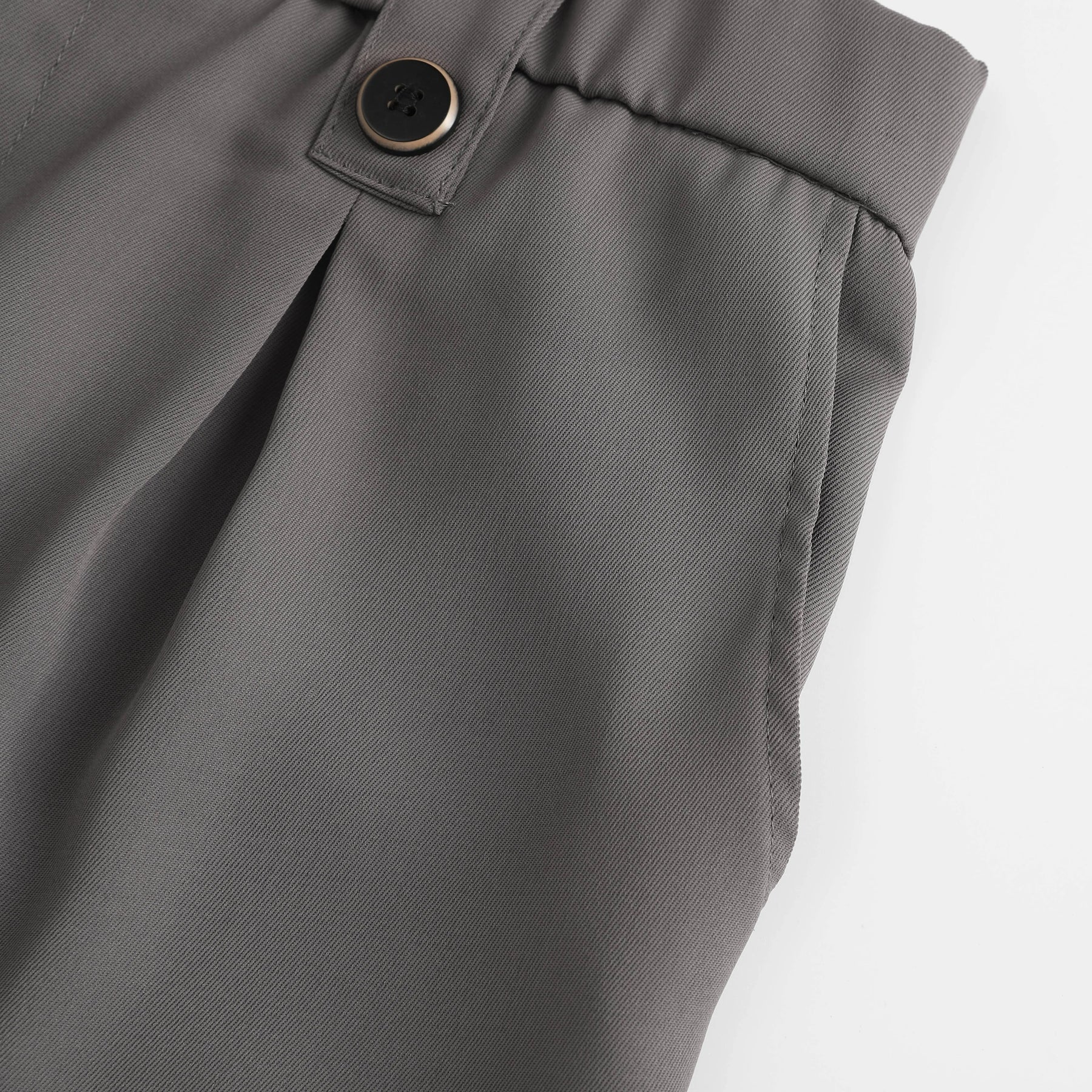 Side detail of tailored pleated suit shorts